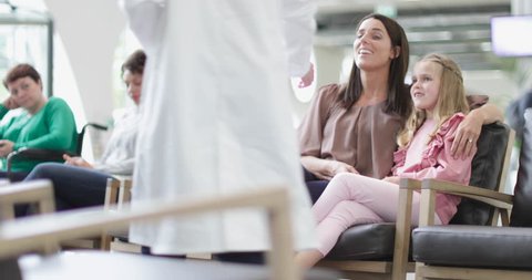 Mother and Child talking with Doctor in waiting room