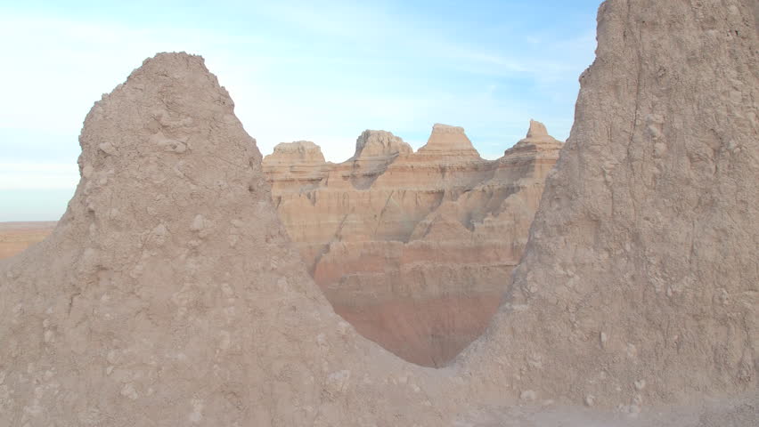 AERIAL: Steep pointy sandstone mountaintops against clear blue sky at Badlands National Park in South Dakota. Outer space landscape with eroded rocky mountain formations in Great Plains grasslands