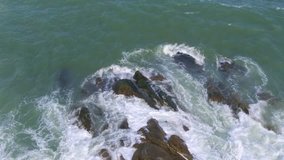 Aerial drone footage of huge waves rushing on shore.