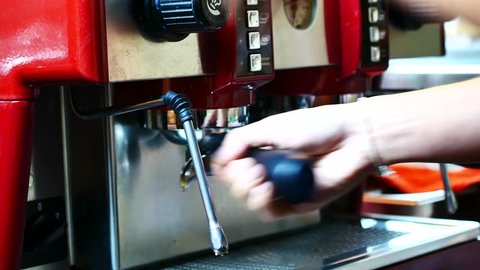 A professional Barista Use a coffee machine to BREW coffee at a customer order at The coffee shop is decorated in a retro style