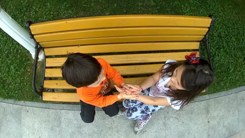 Children playing games with hands in a park .