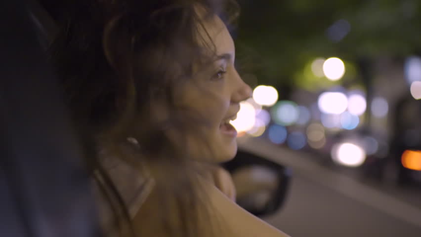 Happy Young Woman Leans Out Passenger Side Car Window, She Looks In Wonder And Awe At All The Beautiful Sights Of The City (Slow Motion) Royalty-Free Stock Footage #27728296