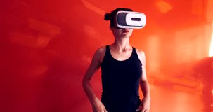 Excited Caucasian female in casual clothes using VR headset indoors, watching 360. Red wall background. 4K UHD RAW edited footage 