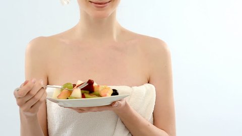 Beautiful young woman in towel eating fruit salad; Full HD Photo JPEG
