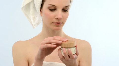 Beautiful young woman wrapped in towel applying moisturizer on hands; Full HD Photo JPEG

