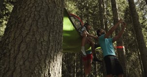 man making smartphone selfie with smiling woman on hanging tent camping in sunny forest. Group of friends summer adventure journey in mountain nature outdoors.People travel exploring.4k slow video