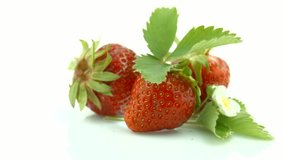Strawberry rotation over white Background. Ripe fresh and juicy Strawberries with leaf and blooming flower close-up. 4K UHD video 3840X2160 