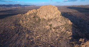 Aerial drone video of large rock formation south of capital Windhoek and railway line area in African savanna landscape in dry season in central highland Khomas Hochland of Namibia, southern Africa