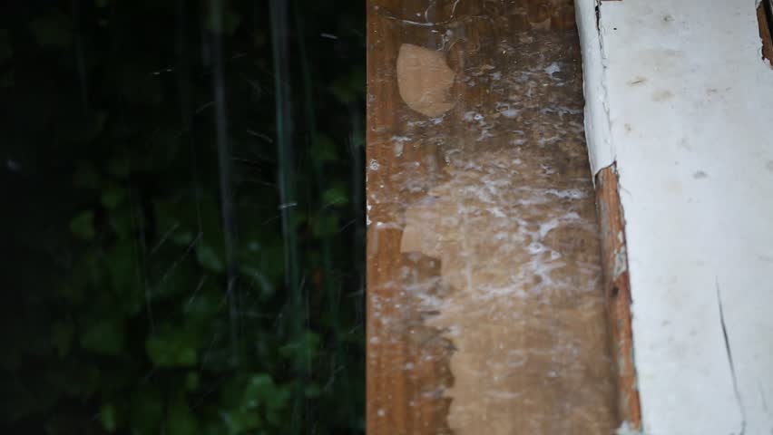 Drops of rain falling on shabby wooden table in yard 