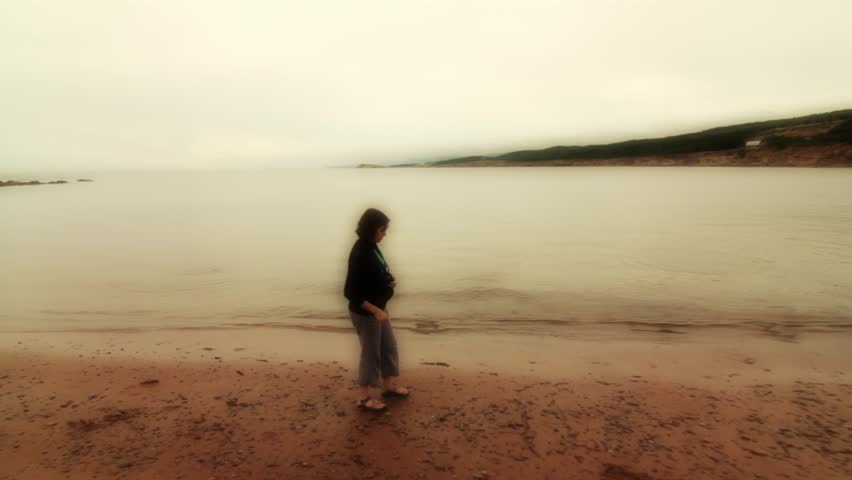 A woman skipping stones into a calm ocean cove