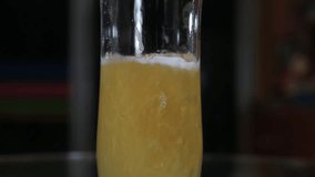 beer poured in glass on turn around in slow motion foam over full top a glass with dark light background -Full HD clip video