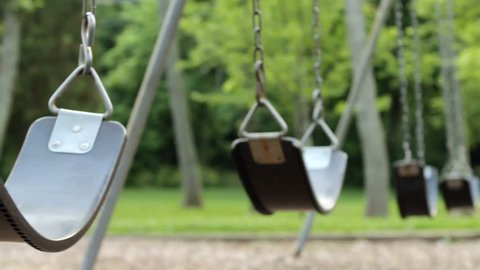 Empty swings swaying at playground