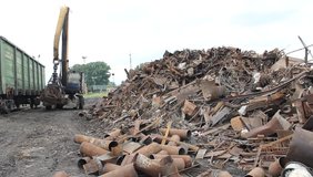 Sorting and loading of scrap metal/Excavator is loading scrap metal junk into a bin at a garbage dump or recycling center. - Powered by Shutterstock - Get 15% off with code: PIKWIZARD15