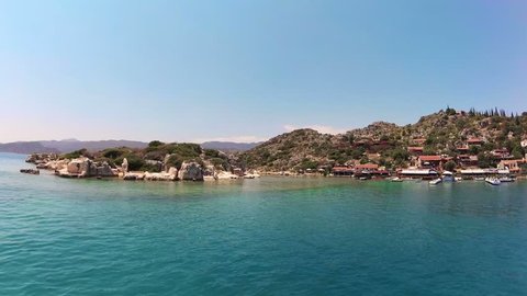 Coast of the island of Kekova in the Mediterranean sea, a modern picturesque village with the ruins of ancient Lycian towns and tombs-sarcophagi of Aperlai, Simena and Teimussa and Dolihiste. Turkey