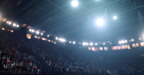 4k video footage of an indoor floodlit basketball arena full of spectators.