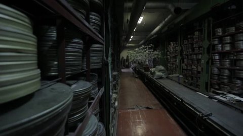 Shelf and conveyor with video film reels in cinema archive.