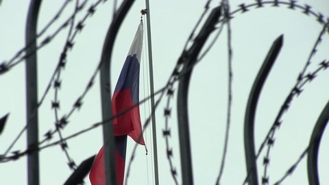 The Barbed Wire on the Sky Background and the Flag of Russia on the Windy Day on. The Concept of Violation of Human Rights in Russia during the Protest Action. Censorship in Russian Mass Media Tools