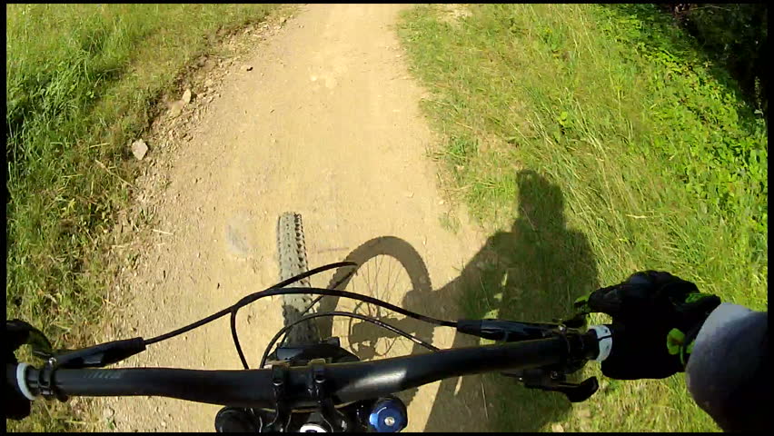 Downhill handlebars view. Ride a bike over terrain pov. 