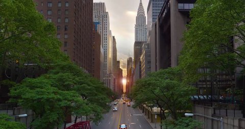 A dramatic wide evening establishing shot over 42nd Street in New York City during "Manhattanhenge."  	
