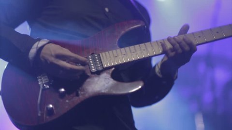 Man lead guitarist playing electrical guitar on concert stage  slow motion