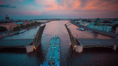 Aerial shot of the ship sails through raised Palace Bridge in Neva river, St. Petersburg, Russia
