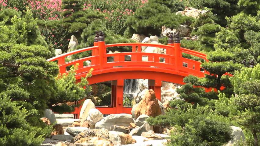 Red Wooden Arch Bridge and Little Waterfall in Nan Lian Garden, Hong Kong.