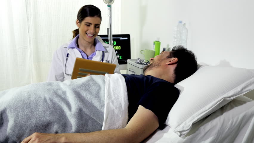 Man lying in bed in hospital laughing with female doctor | Shutterstock HD Video #27842314