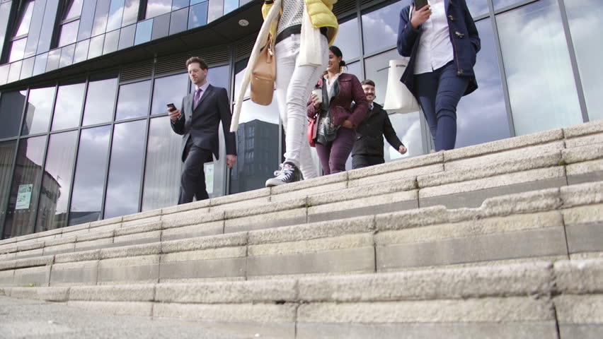 Business people have finished work and have left the building to go home. They are walking down steps while using their smartphones. Royalty-Free Stock Footage #27848503