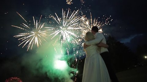 Happy wedding couple watching fireworks. Wedding day.