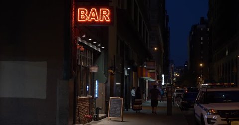 A nighttime exterior establishing shot of a generic, unbranded bar and restaurant in downtown Manhattan, New York. Day/Night matching available. 