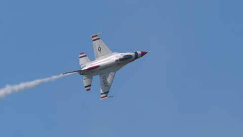 TITUSVILLE, FLORIDA - CIRCA MARCH 2017: USAF Thunderbirds Demonstration Team performs at airshow - amazing shot of jet rolling multiple times in super slow motion against blue sky