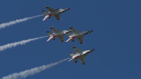 TITUSVILLE, FLORIDA - CIRCA MARCH 2017: USAF Thunderbirds Demonstration Team performs at airshow - four jets flying in tight formation rolling over with smoke trails in super slow motion
