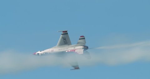 TITUSVILLE, FLORIDA - CIRCA MARCH 2017: USAF Thunderbirds Demonstration Team performs at airshow - single F18 jet passes with smoke trail in slow motion