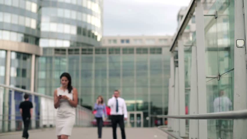 Businesspeople talking on mobile phone in front of skyscrapers
