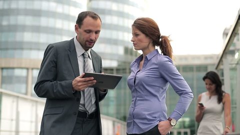 Business couple with tablet having argument in front of skyscrapers
 Stock Video
