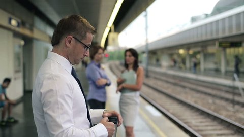 Businesspeople standing on the train station with coffee cup
