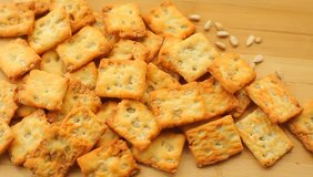 Pile of homemade wholegrain crackers with sunflower seeds on a wooden table - Powered by Shutterstock - Get 15% off with code: PIKWIZARD15