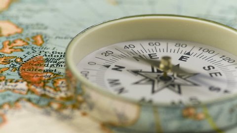 The compass arrow rotates on the geographical map of the world