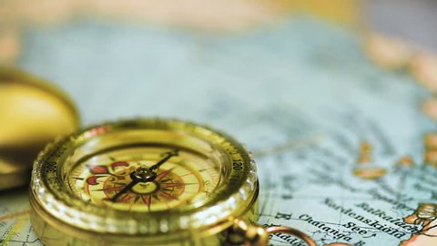 The compass arrow rotates on the geographical map of the world