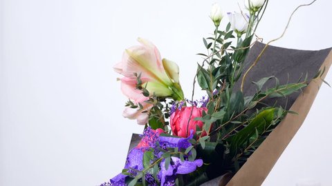 Flowers, bouquet, rotation on white background, floral composition consists of Eustoma, eucalyptus, Amaryllis pink, Orchid vanda, Tulip piano, solidago