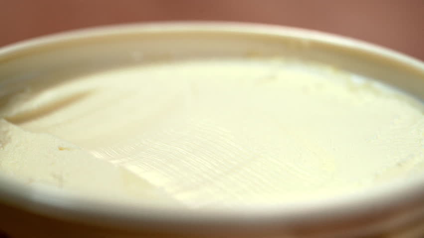 PUTTING KNIFE INTO BUTTER IN THE OPENED BOX. EXTREME CLOSE UP, BLURRED BACKGROUND Royalty-Free Stock Footage #27866092