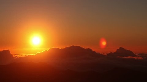 Red sun disk time lapse dawn with flowing cloud waves HDR, shot at Haleakala National Park, Hawaii