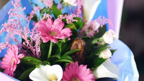 close-up, Flower bouquet in the rays of light, rotation, the floral composition consists of pink gerbera, Protea, calla, Rose yana creamy, solidago Russus.