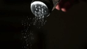 Salt falling in super slow motion from a salt shaker against black background - Powered by Shutterstock - Get 15% off with code: PIKWIZARD15