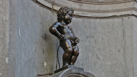 Brussels, Belgium - April 07, 2015: Manneken Pis (Little Man Pee or Le Petit Julien) is small bronze sculpture of a naked little boy urinating into a fountain basin in the inner city of Brussels