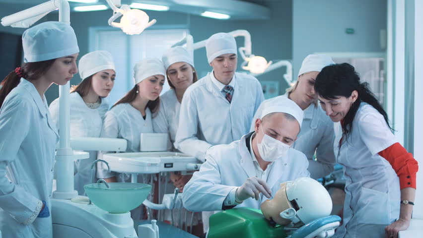 Group of students watching dentist practicing dental activity with mannequin. Royalty-Free Stock Footage #27871756