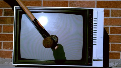 Sledge hammer smashing TV in slow motion