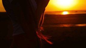 Silhouette of young woman praying at sunset