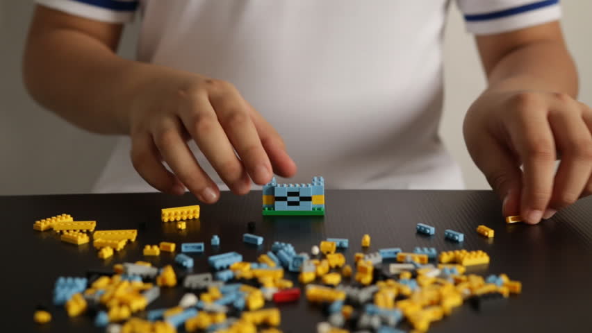 Child's hands playing with a small lego bricks, Hands Close Up. Lego is a popular line of construction toys. Royalty-Free Stock Footage #27883867