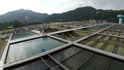 Taipei, Taiwan-05 December, 2015: Aerial view of water treatment facility located in Taipei, northern Taiwan. There are mountains on the horizon and vegetation around. Some pools are empty.